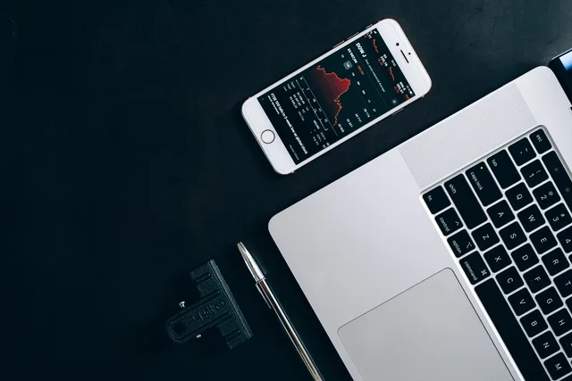 Modern workstation setup showcasing laptop, smartphone, and financial data for business use. Disposing old devices without leaving business data behind