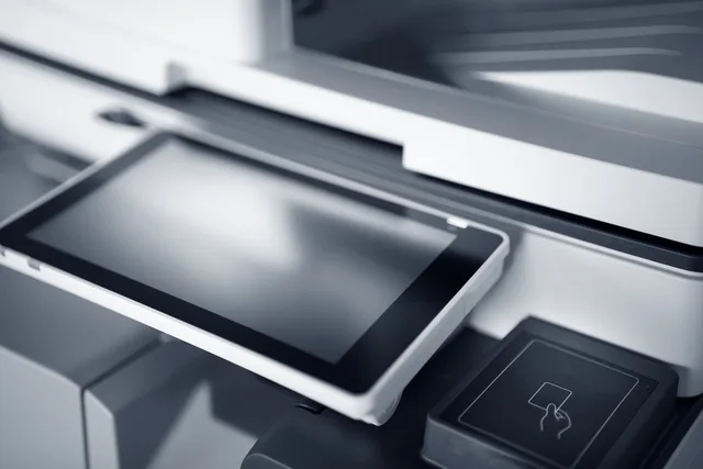 Close-up of a modern printer with a touchscreen interface in a professional office setting. Setting up secure shared printing with Universal Print
